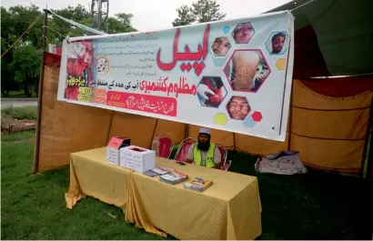  ?? AP file ?? A worker sits in a stall set up by the charity Falah-e-Insaniat Foundation, waiting for donations for Indian Kashmiris, in Islamabad. The group has been put on a government watchlist to curb terrorism financing. —