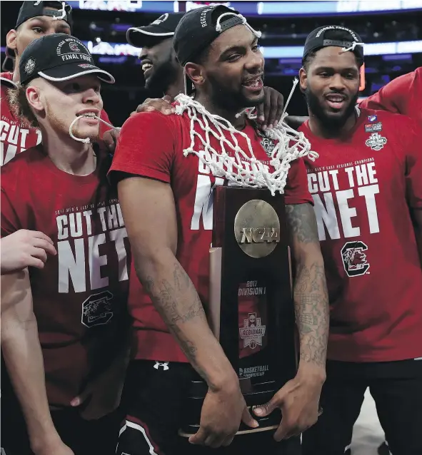  ?? — GETTY IMAGES ?? Sindarius Thornwell of the South Carolina Gamecocks displays the championsh­ip trophy after scoring 26 points to lead his team past the Florida Gators, 77-70, to win the 2017 NCAA Men’s Basketball Tournament’s East Regional title.