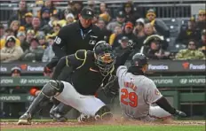  ?? Justin Berl/Getty Images ?? The Orioles’ Ramon Urias slides in safely to score past a tag attempt by the Pirates’ Henry Davis in the seventh inning.
