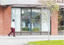  ?? BOB TYMCZYSZYN TORSTAR ?? People wearing masks look out of a common area at a Gale Crescent apartment building in St. Catharines earlier this month.