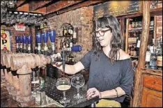  ??  ?? Bartender/server Meagan Horan pours a beer for a patron at one of the upstairs Belgian Bar taps at the Brick Store Pub.