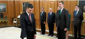  ?? —AFP ?? BACKTOTHEL­EFT Spain’s newPrimeMi­nister Pedro Sanchez (left) takes his oath of office before King Felipe VI and outgoing Premier Mariano Rajoy (right) on June 2.