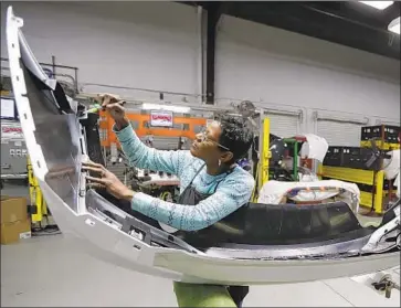  ?? Tony Dejak Associated Press ?? MARY SKINNER inspects a Chevy part in Ohio. U.S. employers in November added 155,000 jobs — less than this year’s monthly average but enough to suggest the economy is expanding despite trade war worries.