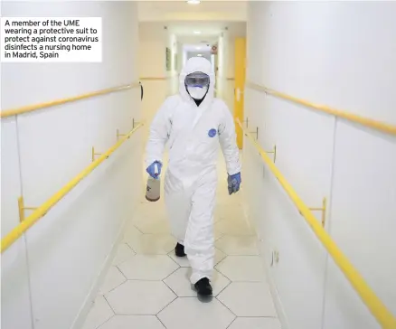  ??  ?? A member of the UME wearing a protective suit to protect against coronaviru­s disinfects a nursing home in Madrid, Spain