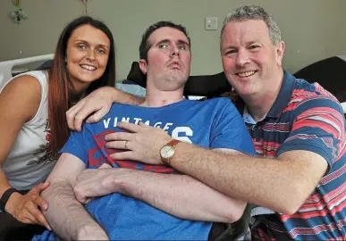  ??  ?? Round-the-clock care: Attack victim Shane Grogan with his father, Joe, and sister, Sarah