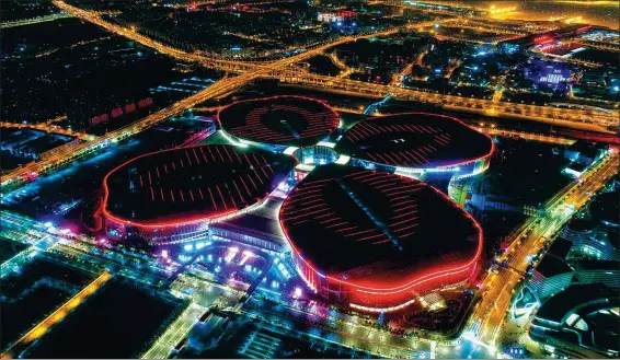  ?? DING TING / XINHUA ?? The National Exhibition and Convention Center in Shanghai lights up the night sky. The six-day China Internatio­nal Import Expo opened at the center on Monday.