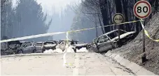  ??  ?? Burnt cars block the road between Castanheir­a de Pera and Figueiro dos Vinhos, central Portugal, yesterday. Raging forest fires in central Portugal killed at least 50 people, many of them trapped in their cars as flames swept over a road Saturday...