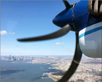  ?? ERIC KORT — UNIVERSITY OF MICHIGAN VIA AP ?? In this 2018 photo, a Twin Otter aircraft flies over New York Harbor and New York City on a research mission. In older Eastern U.S. cities, nine times as much natural gas is leaking out of pipelines, homes than federal government had thought. NOAA’s airplane sees much more methane coming out of New York City, Washington, Boston, Philadelph­ia, Baltimore and Providence than EPA had figured. Scientists said Monday it isn’t a safety problem, but it is a climate change issue. Fixing those leaks can help in the fight against global warming.