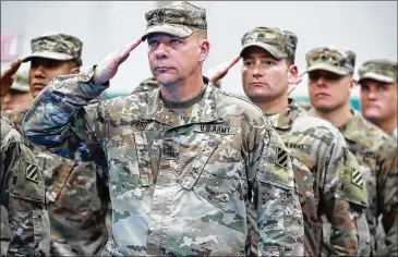  ?? CURTIS COMPTON / CCOMPTON@AJC.COM ?? 1st Sgt. Archer Ford (from left), Sgt. 1st Class Neal Andreson and members of the Georgia National Guard’s 48th Brigade Combat Team salute the colors.