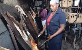  ??  ?? Garcia Green, a worker on the Spicy Hill Farm, preparing goat skin for one of the products created on the farm.