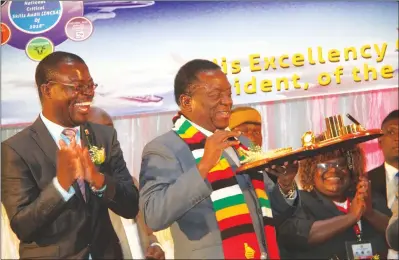  ?? — (Picture by Justin Mutenda) ?? President Mnangagwa admires a token of appreciati­on he received during the National Critical Skills Audit, National Geospatial and Space Agency and National Qualificat­ion Framework launch, while Higher and Tertiary Education, Science and Technology Developmen­t Minister Amon Murwira (left) and other delegates cheer in Harare yesterday.