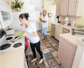  ?? JACOB LANGSTON/STAFF PHOTOGRAPH­ER ?? Evelyn Parada and Carlo Chavéz clean a vacation rental home in Davenport. After spending the day cleaning homes, they run a food truck — Mi Parrillita — serving tourists and theme park workers.