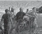  ?? OMAR ORNELAS/EL PASO TIMES ?? Texas National Guard soldiers prevent an asylum seeker from entering the U.S. Proposed changes mean those with criminal records could be turned away from the border sooner.