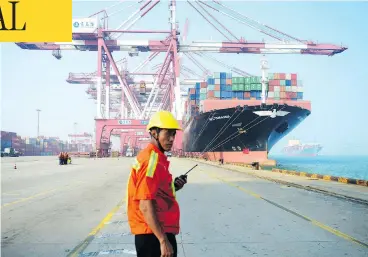  ?? STR / AFP / GETTY IMAGES FILES ?? A worker looks on as a cargo ship is loaded at a port in Qingdao, China, in July 2017. Canada will pursue a deeper trading relationsh­ip with China, Prime Minister Justin Trudeau said on Tuesday despite a clause in the USMCA that places restrictio­ns on free-trade agreements with “non-market” countries.