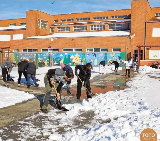  ??  ?? Vecinos ayudan a una cuadrilla municipal a limpiar el acceso a un colegio en la localidad madrileña de Colmenar Viejo