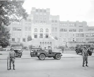  ?? Associated Press file photo ?? n In this Sept.
26, 1957, file photo, members of the 101st Airborne Division take up positions outside Central High School in Little Rock, Ark. The troopers were on duty to enforce integratio­n at the school. Officials said Wednesday that newly...
