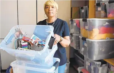  ?? KIM HAIRSTON/BALTIMORE SUN ?? Bertha Knight, a community school coordinato­r for Child First Authority at Robert W. Coleman Elementary School, has a bin of hygiene and personal care products as well as food gift cards for families in need.