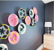  ??  ?? Colourful baskets made by a Rwandan women’s collective hang on a dark wall to provide a graphic punch in this room.