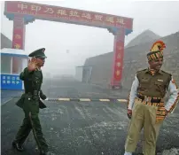  ?? AFP file ?? A Chinese soldier and an Indian soldier posted at the Nathu La border crossing. —