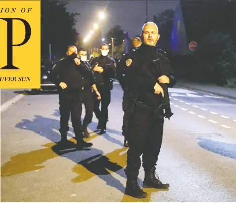  ?? CHARLES PLATIAU / REUTERS ?? Police officers secure the area near the scene of a fatal stabbing in the Paris suburb of Conflans Sainte-honorine on Friday. The teacher killed in the attack had shown pupils cartoons of the Prophet Mohammad considered by Muslims to be blasphemou­s, according to a police source.