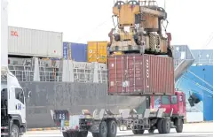  ??  ?? A crane unloads cargo containers onto a truck at Laem Chabang port.