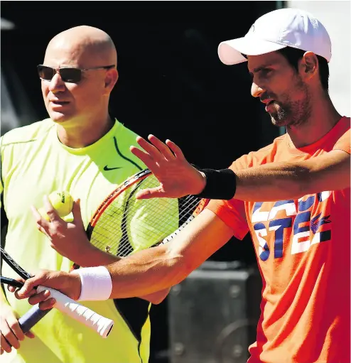  ?? CHRISTOPHE SIMON / AFP / GETTY IMAGES ?? Serbia’s Novak Djokovic, right, flanked by coach Andre Agassi, hasn’t won a Grand Slam title in over a year.