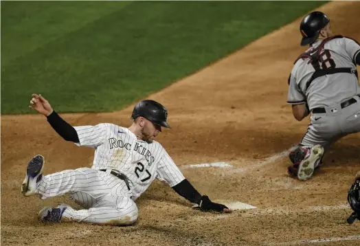  ?? AAron Ontiveroz, The Denver Post ?? Colorado’s Trevor Story scores on a double by Charlie Blackmon against the Arizona Diamondbac­ks to take a 4-2 lead in the bottom of the eighth inning at Coors Field on Tuesday night.