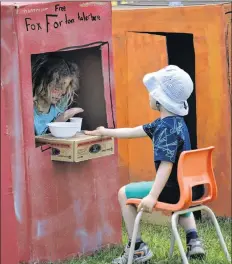  ??  ?? One of the booths in the kids’ marketplac­e was a fortune telling booth. Sayde Nightingal­e, 9, from Halifax, creatively told five-year-old Eric E., of Wolfville, his wild and crazy fortune.