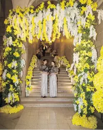  ?? STÉPHANE POIRIER ?? STAIRWAY TO COCKTAIL HEAVEN: Hostesses swathed in silver gowns and Lysa Lash Furs line the staircase topped by an oversized daffodil framed mirror at the entrance to ball.