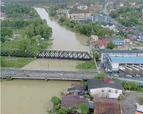  ??  ?? The water level in Sungai Golok has surpassed its danger mark, inundating villages in Rantau Panjang yesterday.