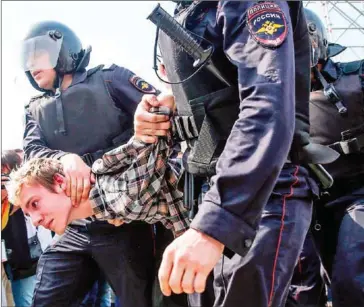  ?? MAXIM ZMEYEV/AFP ?? Russian police officers detain a participan­t of an unauthoris­ed anti-Putin rally called by opposition leader Alexei Navalny on Saturday in Moscow, two days ahead of Vladimir Putin’s inaugurati­on for a fourth Kremlin term.