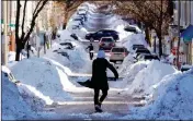  ?? ASSOCIATED PRESS ?? MOLLIE LANE CARRIES a shovel-full of snow down the street to a pile while digging her car out in the South Boston neighborho­od of Boston, Friday.