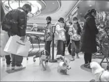  ?? PROVIDED TO CHINA DAILY ?? Pet owners shop with their dogs at a pet store in a Beijing shopping mall in January.