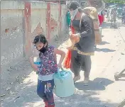  ?? GURPREET SINGH/HT ?? ■
A girl carrying water walks towards Ludhiana railway station to board a train to her home town on Tuesday.