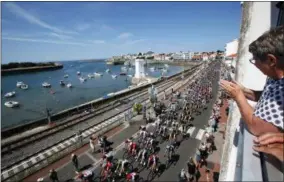  ?? CHRISTOPHE ENA — THE ASSOCIATED PRESS ?? Spectators watch as the pack passes along the west coast during the first stage of the Tour de France cycling race over 201kilomet­ers (124.9miles) with start in Noirmoutie­ren-L’Ile and finish in Fontenay Le-Comte, France, Saturday.