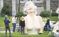  ?? Michael Cummo / Hearst Connecticu­t Media ?? Stamford resident Jean-Marc Longo takes a photo of his wife Di Longo as she poses next to Marilyn Monroe’s torso in Latham Park in downtown Stamford on Monday.