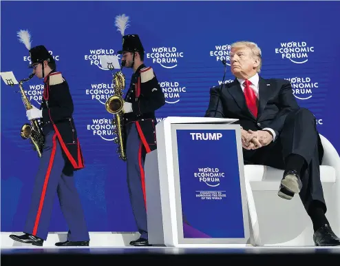 ?? FABRICE COFFRINI / AFP / GETTY IMAGES ?? U. S. President Donald Trump watches a band leave the stage on Friday before delivering his speech to the World Economic Forum annual meeting in Davos, Switzerlan­d, where he touted the U. S. as a trading partner.