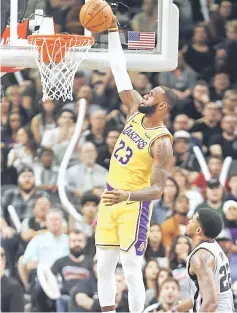  ??  ?? LeBron James (top) of the Los Angeles Lakers dunks past Rudy Gay of the San Antonio Spurs at AT&amp;T Centre in San Antonio, Texas. — AFP photo