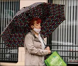  ?? Lori Van Buren / Times Union ?? A pedestrian uses an umbrella as she walks on State Street in steady rain Tuesday. Flood watches continue Wednesday in some areas.