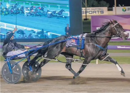  ?? Scott Hamilton ?? Mark Purdon lifts his whip in salute as Lazarus claims the Interdomin­ion Final at Gloucester Park, Perth.