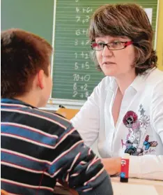  ??  ?? Christoph Woithon in einem der Übergangsr­äume für die Klassen für Kranke am Jo sefinum in Augsburg (oben). Eine Lehrerin der Frère Roger Schule im Gespräch mit einem Schüler (unten).