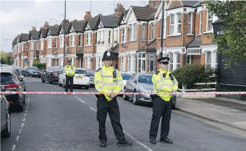  ?? STEFAN ROUSSEAU / PRESS ASSOCIATIO­N VIA THE ASSOCIATED PRESS FILES ?? Police officers man the cordoned- off area in London’s Harlesden Road April 28 after counter-terror police shot a woman and arrested several people in raids in London and Kent. The woman who was shot has been charged.