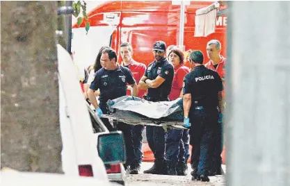  ??  ?? Bombeiros recolhem o corpo da vítima, na Rua Luís de Camões, em Algés, onde o crime ocorreu ontem de manhã