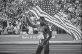  ?? LOS ANGELES TIMES FILE PHOTO ?? American sprinter — and birthday boy — Carl Lewis humbly waves the American flag after humbly winning another race.