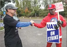  ?? MATT ROURKE / ASSOCIATED PRESS ?? Picketing United Auto Workers members Richard Rivera (left) and Will Myatt react to news of a tentative contract agreement with General Motors, in Langhorne, Pennsylvan­ia, on Wednesday.