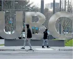  ?? THE CANADIAN PRESS FILES ?? A man on a skateboard and a young woman pass large letters spelling out UBC at the University of British Columbia in Vancouver in 2015. The federal government is writing off more than $ 200 million in outstandin­g student loan payments that officials...