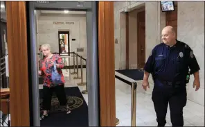  ?? Democrat-Gazette file photo ?? Brad Hartness of the State Capitol Police greets Jeannie McCarroll at an entrance to the Capitol in 2015. Some people, including lobbyists and others who don’t have offices in the Capitol, have been receiving electronic cards so they can avoid the security detectors, but a new policy by the secretary of state’s office will begin limiting the number of cards.