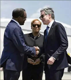  ?? AP ?? Secretary of State Antony Blinken is greeted Monday as he arrives at the internatio­nal airport in Kingston, Jamaica, by the U.S. Ambassador to Jamaica, N. Nick Perry (left). Blinken met later with Caribbean leaders in Jamaica as part of an urgent push to solve Haiti’s spiraling crisis.