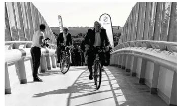  ??  ?? Le maire de la Rosny-sur-Seine, Michel Guillamaud, à vélo, pour l’inaugurati­on de la passerelle.