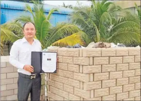  ?? FB ?? Eco-Bricks company director Sok Thy shows off the certificat­ion he received for his products in August.